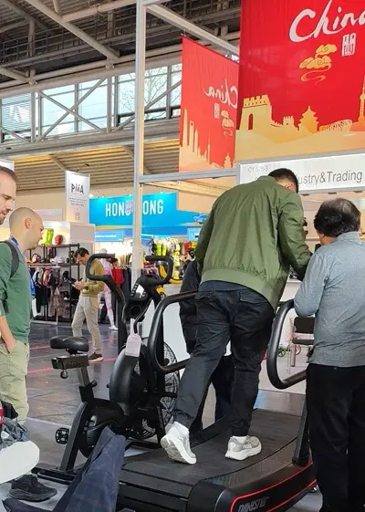 Visitor trying curved treadmill at ISPO 2025