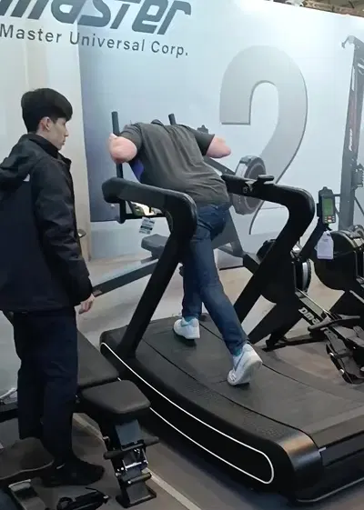 Visitor trying the curved treadmill at FIBO 2025