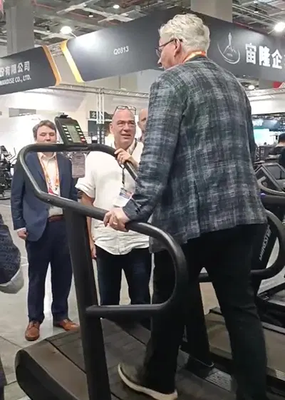 Visitor trying curved treadmill at TAISPO 2025