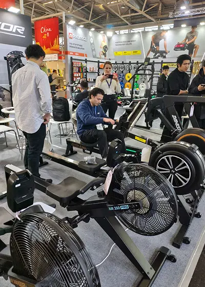 Visitor exploring VEKTOR rower at ISPO 2025